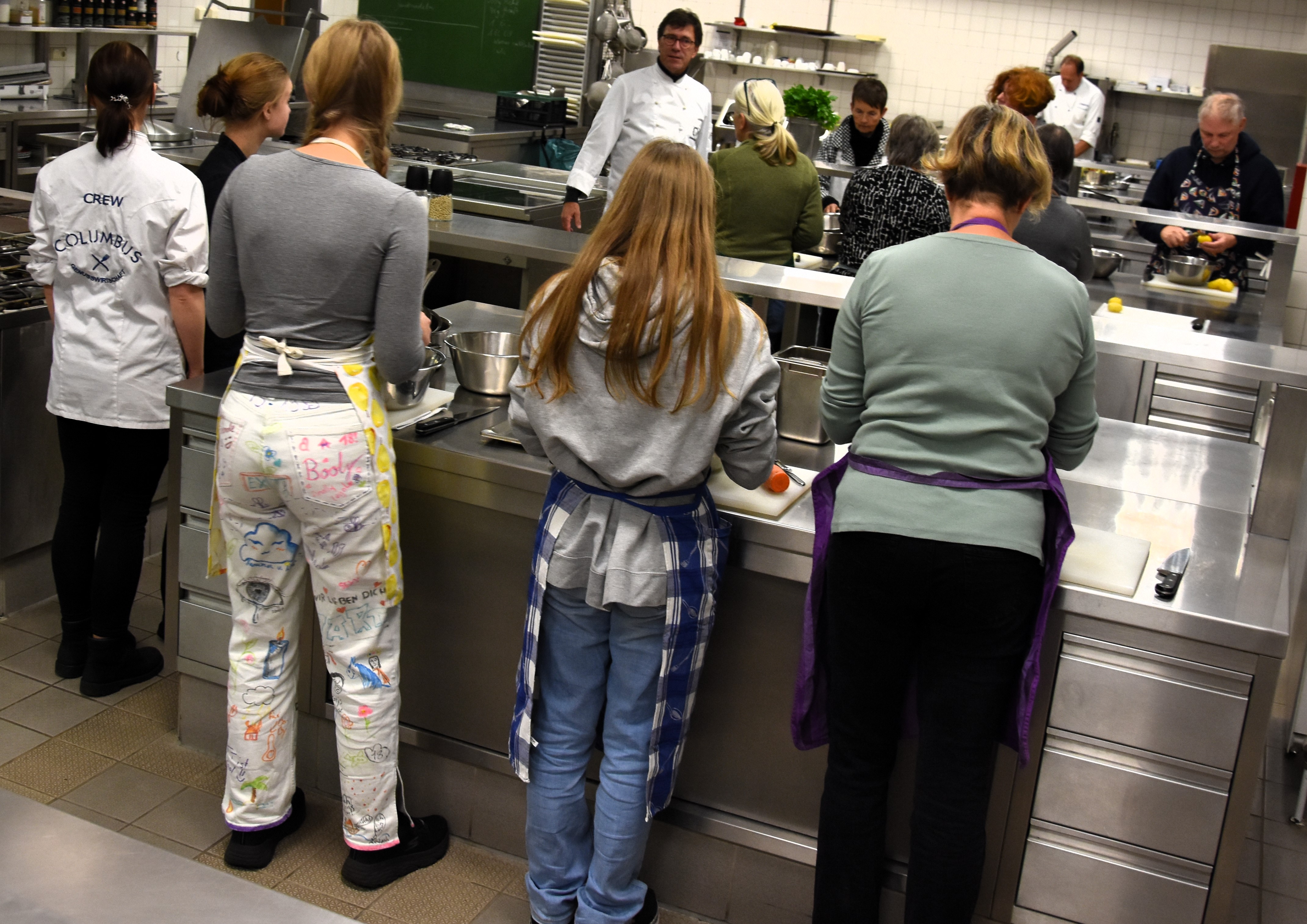 Unter fachlicher Anleitung von Johannes Hartwig (2. Reihe, links) und Jens Ingwersen (Bildhintergrund) wurde in der Ausbildungsküche der Hannah-Arendt-Schule klimafreundlich gekocht.